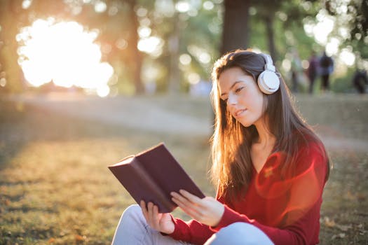 young adult listening to a podcast in a park